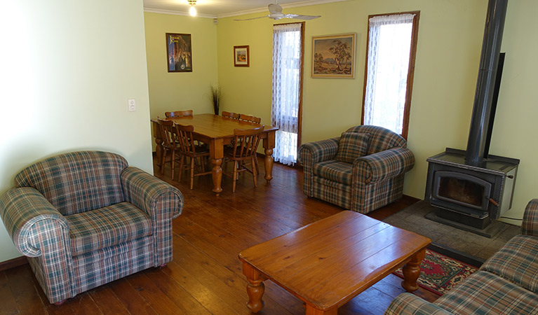 Lounge chairs, fireplace, and dining table in Arch Cottage, Abercrombie Karst Conservation Reserve. Photo: Stephen Babka/DPIE