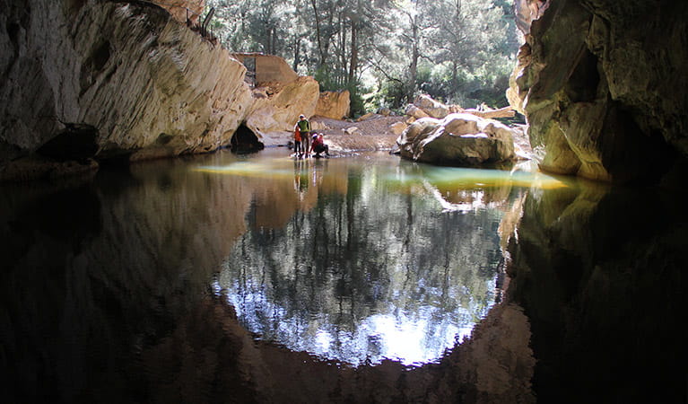 A family beside a pool of water at the entrance to Archway Cave, Abercrombie Karst Conservation Reserve. Photo: Stephen Babka/DPIE