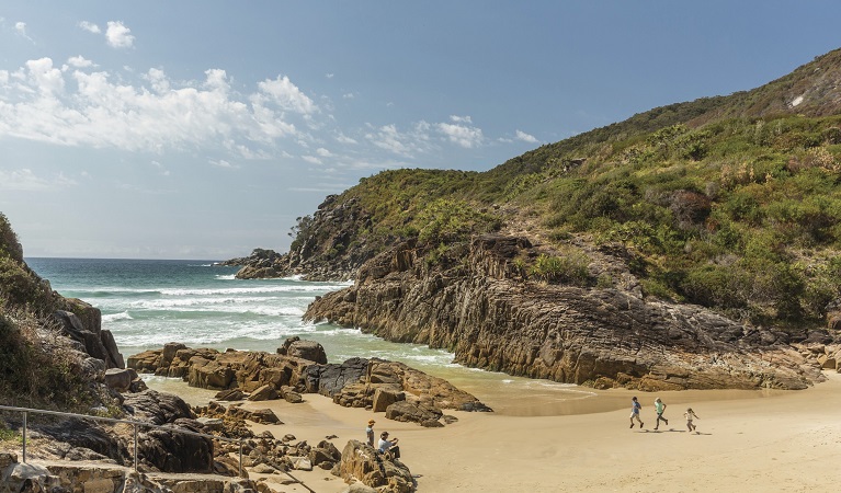 Family running along Little Bay beach, Arakoon National Park. Photo: David Finnegan/DPIE