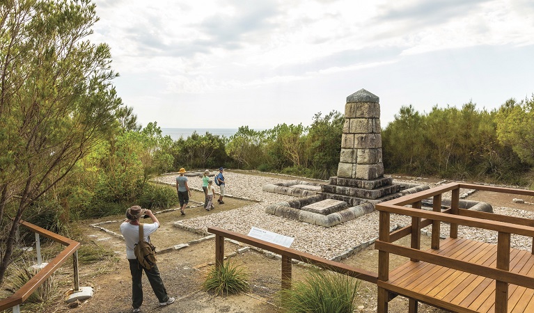 Visitors standing by the monument tribute at Arakoon National Park. Photo: David Finnegan &copy; OEH