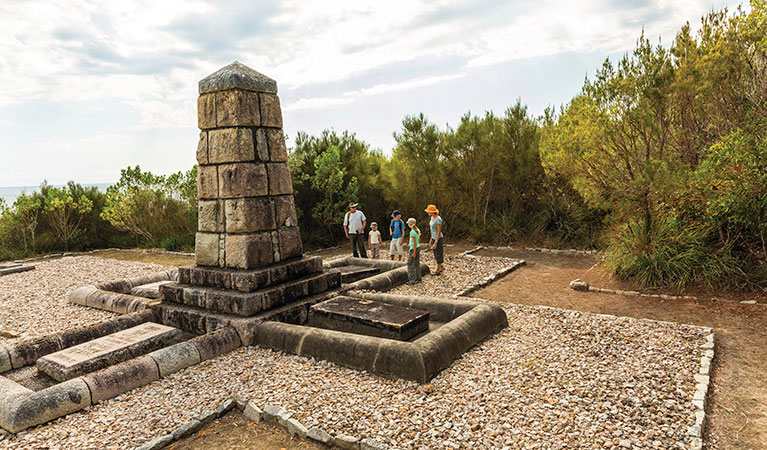 Visitors standing by the monument tribute at Arakoon National Park. Photo: David Finnegan/DPIE