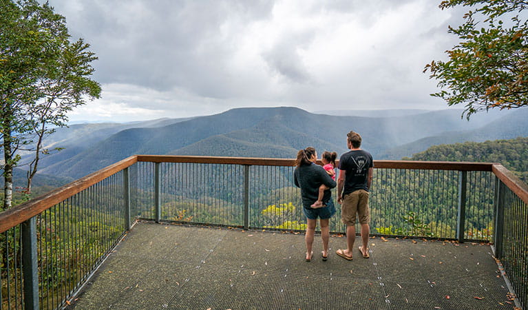 A family of 3 taking in the view from Devils Hole lookout in Barrington Tops National Park. Photo: John Spencer/DPIE