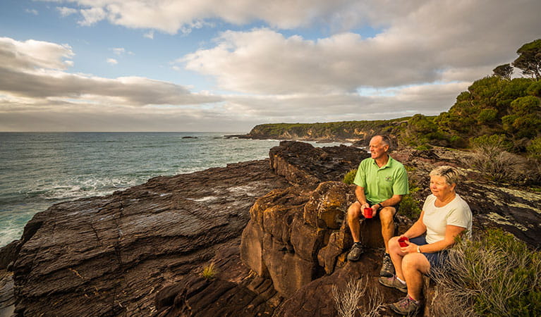 People relaxing on ocean cliffs at Bittangabee campground, Beowa National Park. Photo: John Spencer/OEH