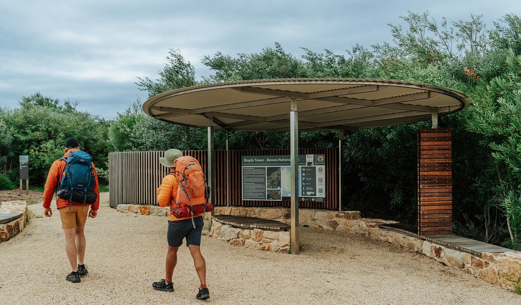Two visitors stroll past the interpretation sign at Boyds Tower in Beowa National Park. Credit: Remy Brand/DCCEEW &copy; Remy Brand