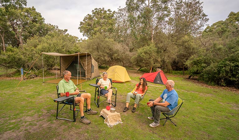 Campers sitting around the campfire at Saltwater Creek campground. Photo: John Spencer/DPIE