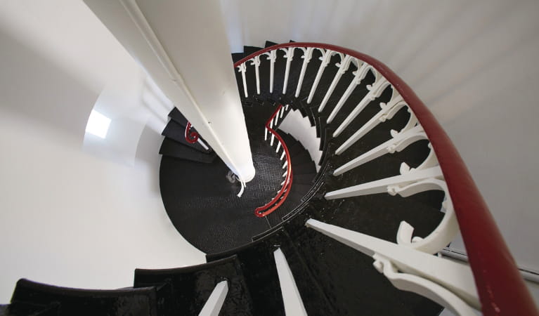 Black steel spiral staircase with white wrought iron railing and polished wood banister. Photo: Nick Cubbin &copy; DPIE