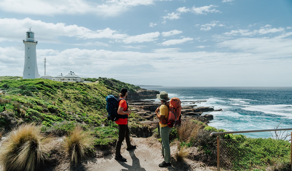 Two visitors take in the panoramic views out over the rugged coastline from Green Cape Lighthouse. Credit: Remy Brand/DCCEEW &copy; Remy Brand