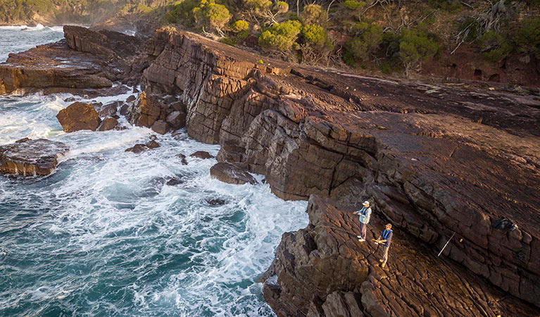 2 people fishing from the top of the rocks near Bittangabee Bay. Photo: John Spencer &copy; DPIE