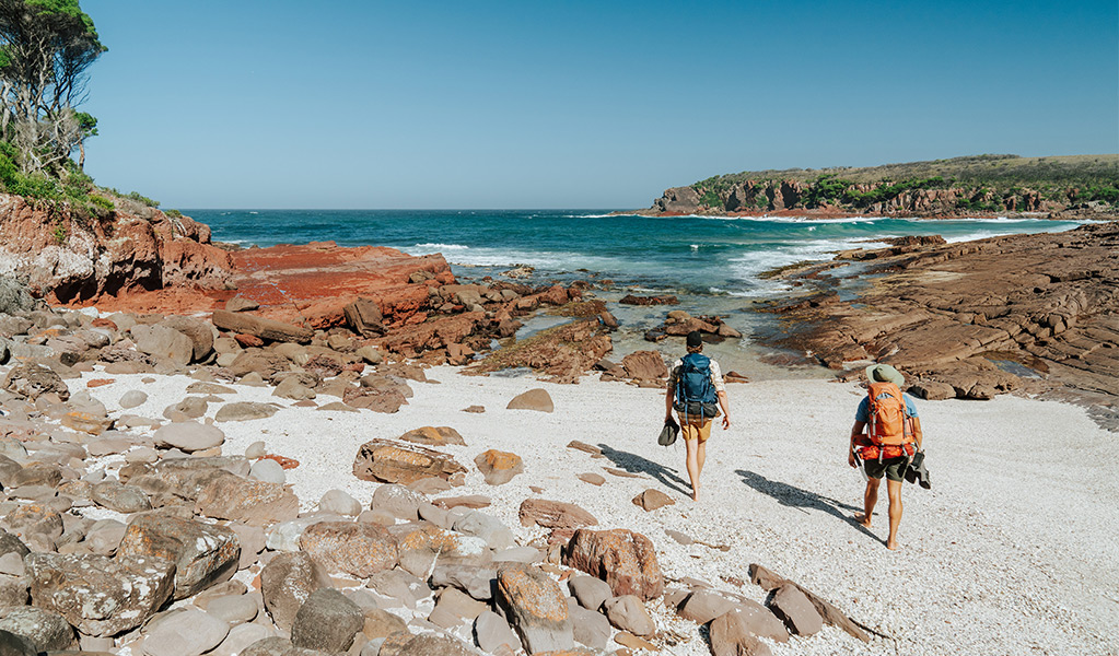 Hikers arriving at Hegartys Bay, a small rocky beach. Credit: Remy Brand/DCCEEW © Remy Brand