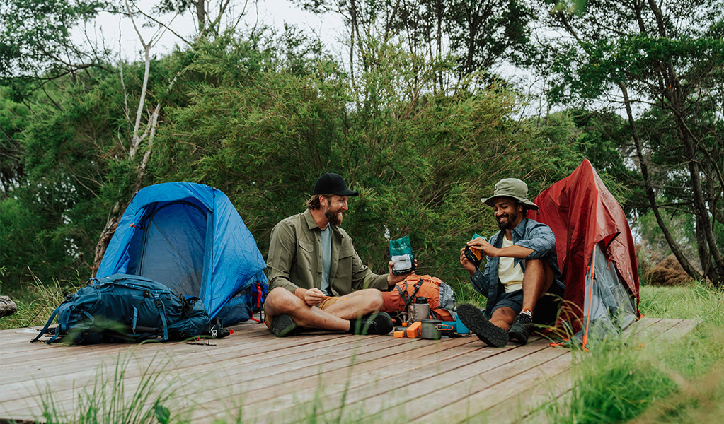 Hikers relaxing on their hardwood tent platform at Mowarry campground. Credit: Remy Brand/DCCEEW &copy; Remy Brand