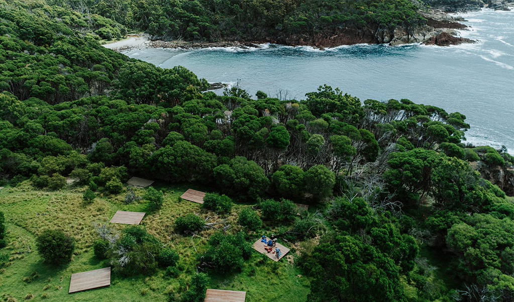 Aerial view of hardwood tent platforms set back from the water at Mowarry campground. Credit: Daniel Parsons/DCCEEW © Daniel Parsons
