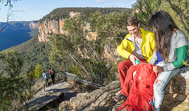 A couple sit on a rock at Evans lookout, Blue Mountains National Park. Photo: Simone Cottrell/OEH