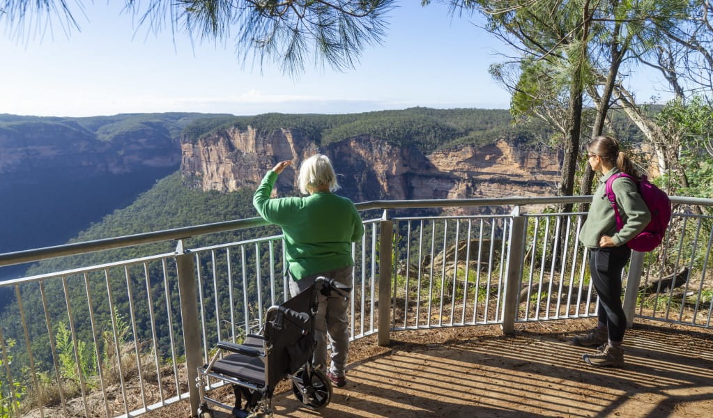 2 visitors taking in the view from Evans lookout in the Blackheath area of Blue Mountains National Park. Photo: Simone Cottrell/DPE &copy; DPE