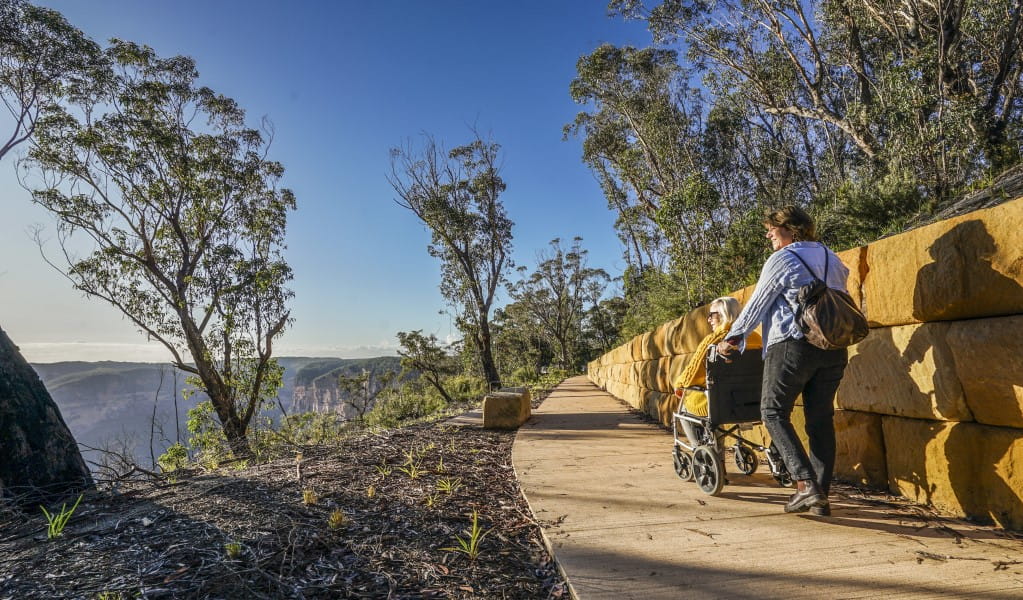 2 visitors along a path at Evans lookout in Blue Mountains National Park. Photo: Simone Cottrell/DPE &copy; DPE