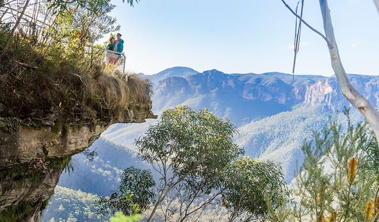 Walkers looking out at views from Breakfast Rock,  Govetts Leap descent walk. Photo: OEH/Simone Cottrell