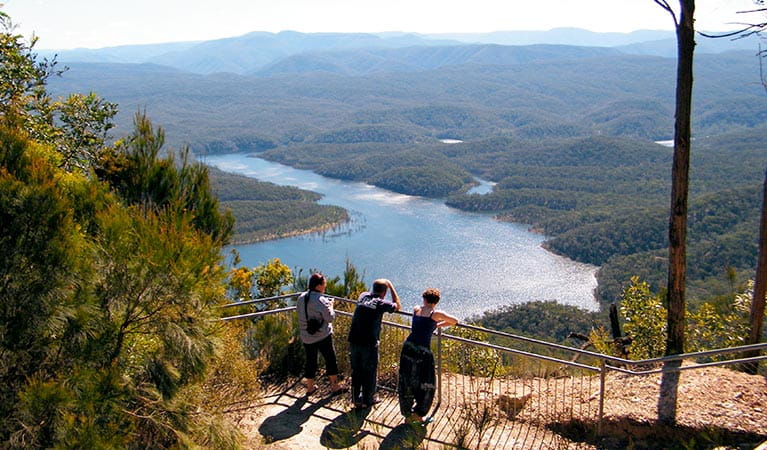 Three people at McMahons Point lookout above Lake Burragorang, Blue Mountains National Park. Photo: Craig Marshall/OEH