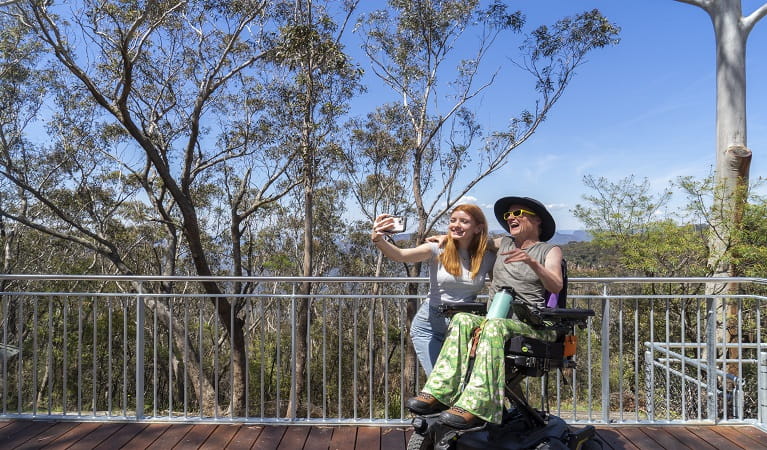 Visitors taking a photo from Valley of the Waters lookout in Blue Mountains National Park. Photo: Simone Cottrell © DPE