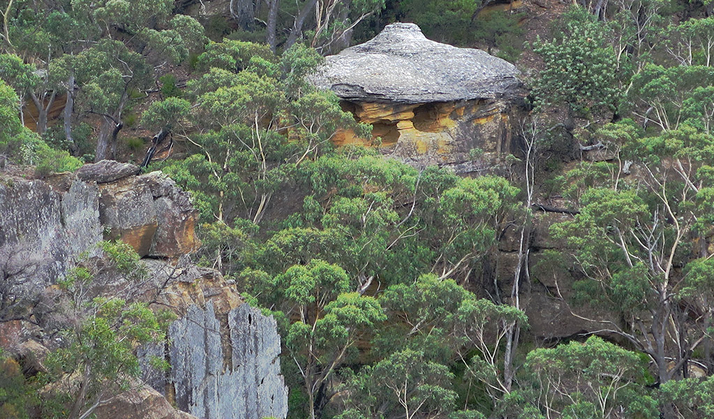 View of hat-like rock formation set in a steep and rocky bush landscape. Photo credit: Elinor Sheargold &copy; DPE