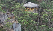 View of hat-like rock formation set in a steep and rocky bush landscape. Photo credit: Elinor Sheargold &copy; DPE