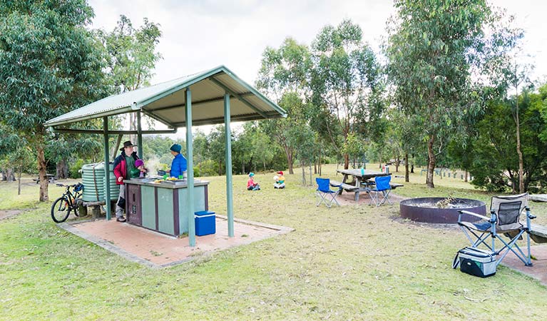 A family cooks on undercover gas barbecues at Dunphys campground, Blue Mountains National Park. Photo: Simone Cottrell/OEH