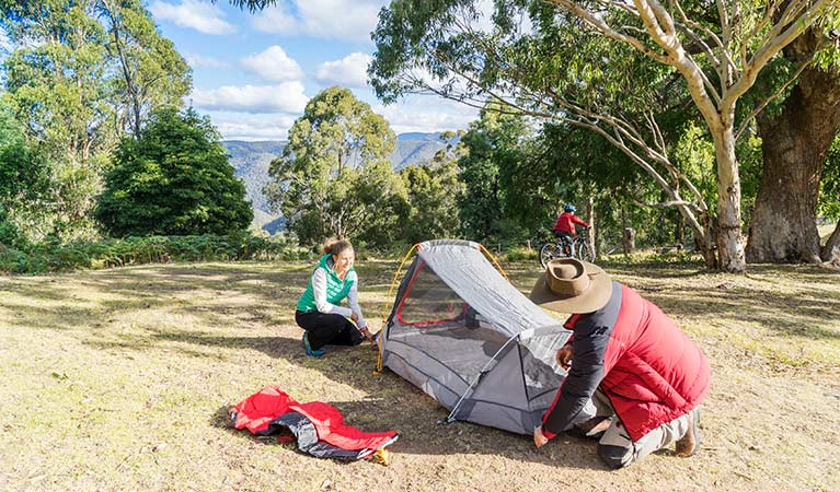 A couple pitch a tent at Dunphys campground, Blue Mountains National Park. Photo: Simone Cottrell/OEH.