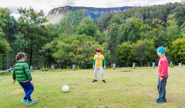 Three kids play soccer at Dunphys campground, Blue Mountains National Park. Photo: Simone Cottrell/OEH.