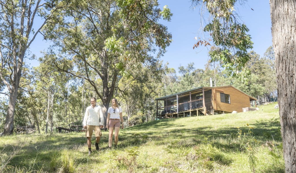 A couple walking down the hill outside Galong cabins in the Southern Blue Mountains area of Blue Mountains National Park. Photo: Simone Cottrell &copy; DPIE