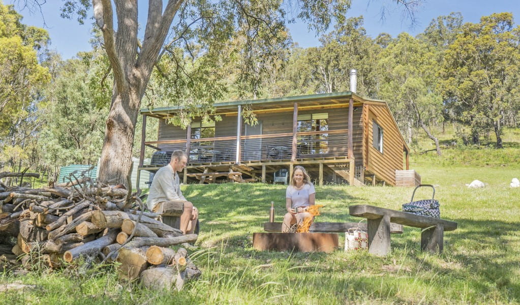 A couple having a picnic at the fire pit outside Galong cabins in the Southern Blue Mountains area of Blue Mountains National Park. Photo: Simone Cottrell &copy; DPIE