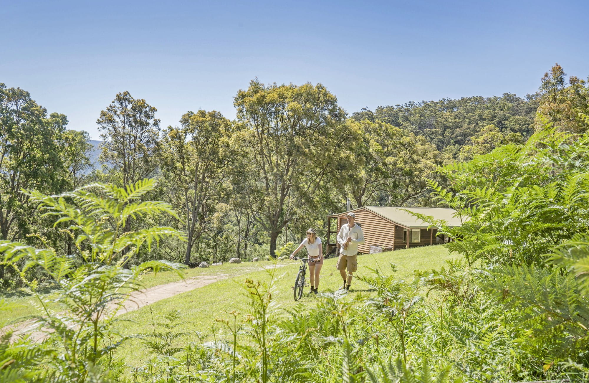 A couple walking up the hill from Galong cabins in Blue Mountains National Park. Photo: Simone Cottrell &copy; DPIE