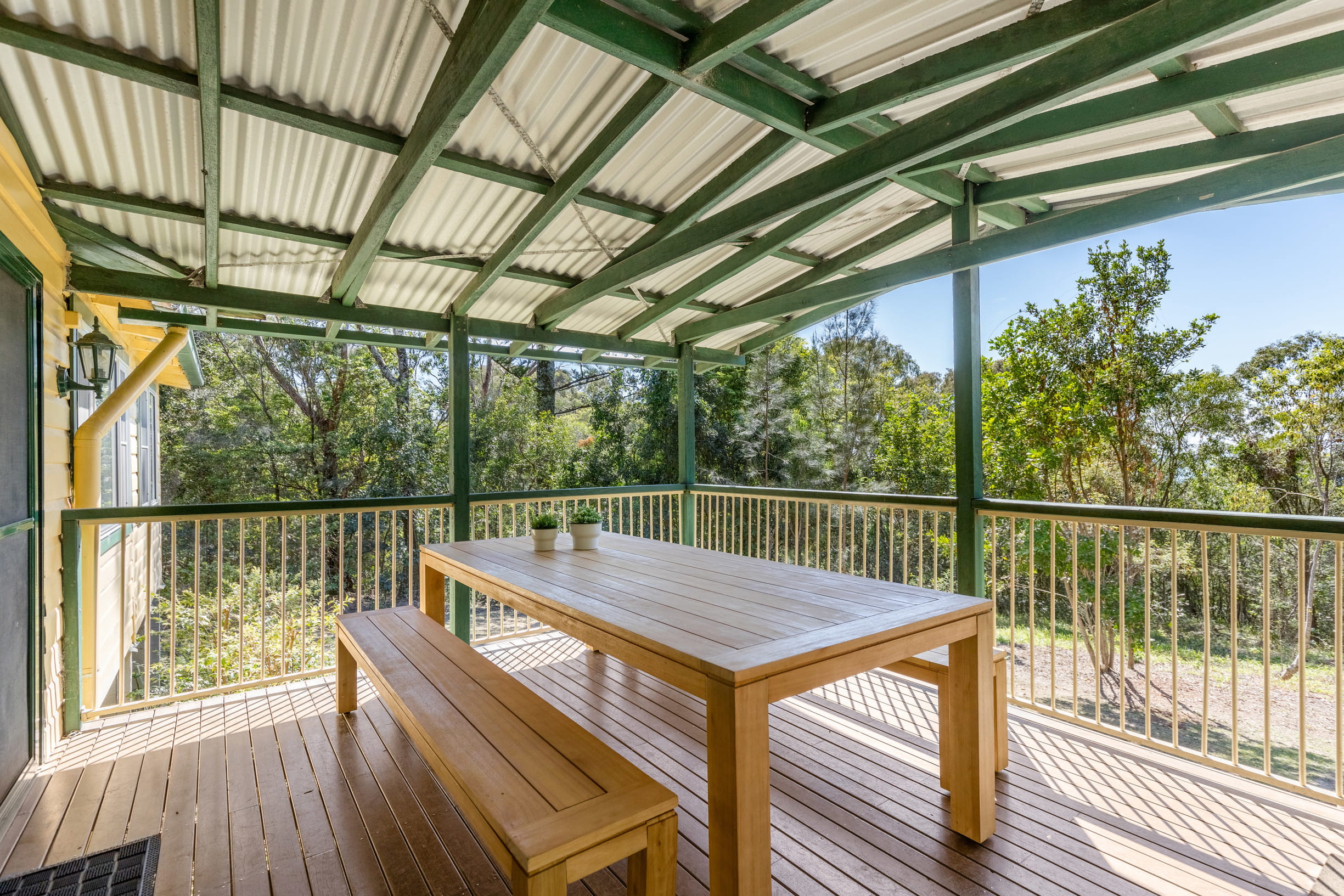 The verandah with outdoor table and benches at Tuckers Rocks Cottage in Bongil Bongil National Park. Photo: Mitchell Franzi/DPIE