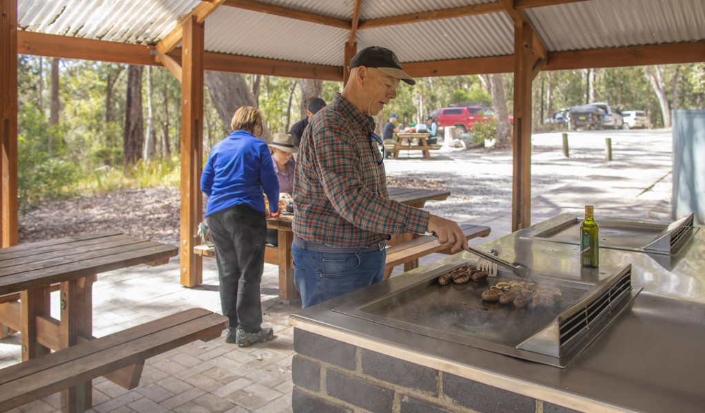 A group of people having a picnic under the shelter at Boonoo Boonoo Falls picnic area in Boonoo Boonoo Falls National Park. Photo: Joshua Smith &copy; DPE