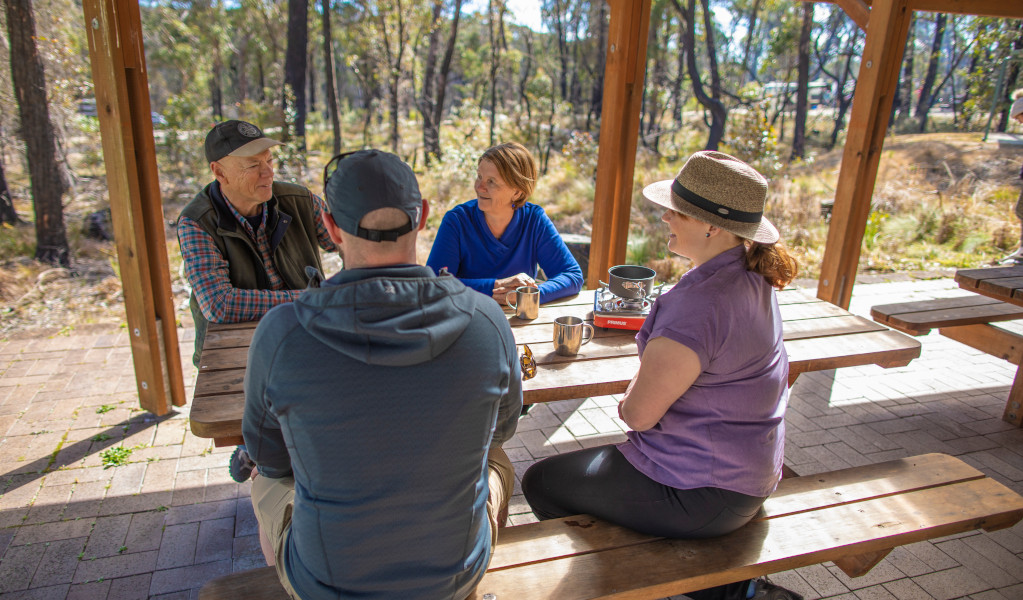 Campers siting at picnic tables, Cypress Pine campground. Credit: Joshua J Smith &copy DPIE