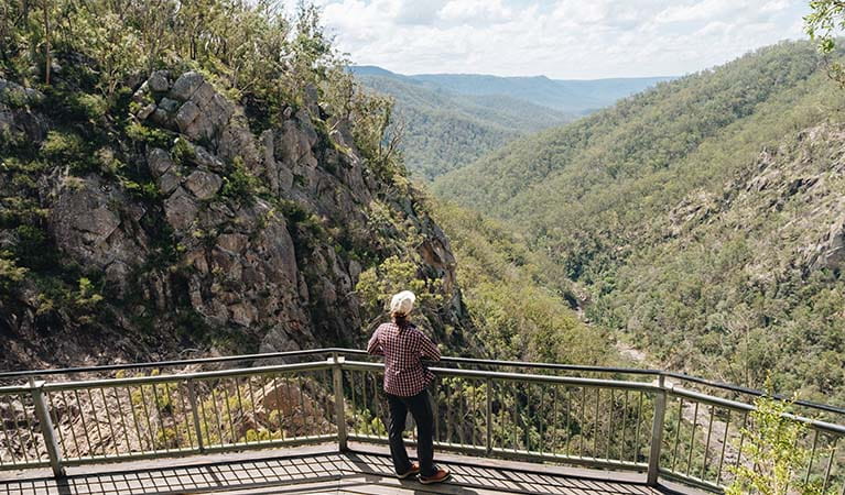 A visitor looks out over a steep rocky valley from Boonoo Boonoo Falls lookout in Boonoo Boonoo National Park. Photo credit: Harrison Candlin &copy; Harrison Candlin