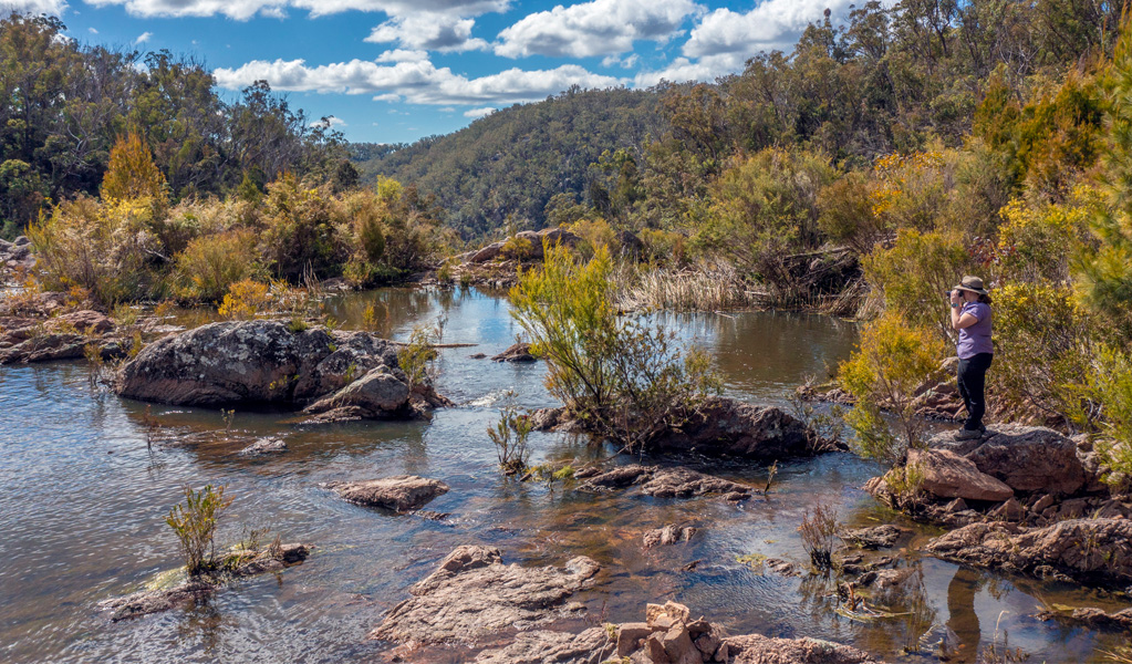 Person looking out over rockpools in Boonoo Boonoo National Park. Photo: Joshua J Smith, &copy; DCCEEW