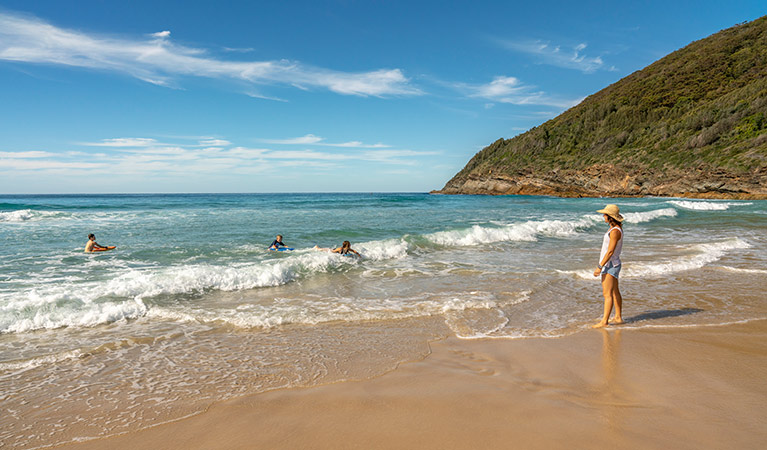 A mother watches her children play in the ocean, at Seven Mile Beach near The Ruins campground in Booti Booti National Park. Photo credit: John Spencer &copy; DPIE