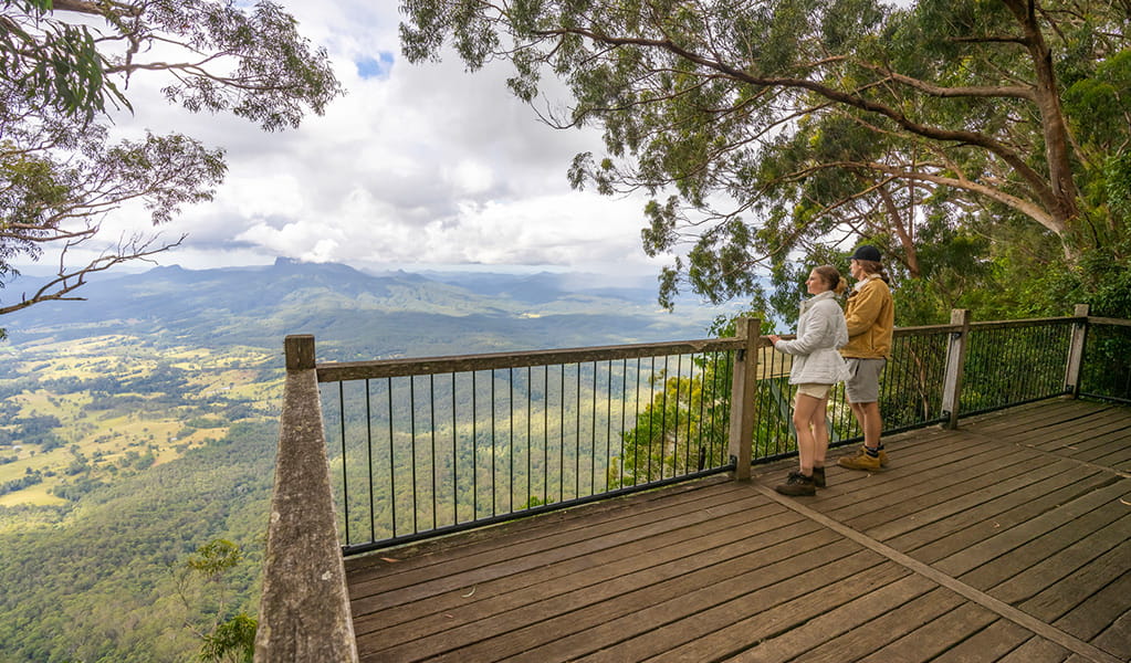 2 visitors looking at the view of Wollumbin - Mount Warning and Tweed Valley at Blackbutt lookout picnic area. Credit: John Spencer &copy; DPE
