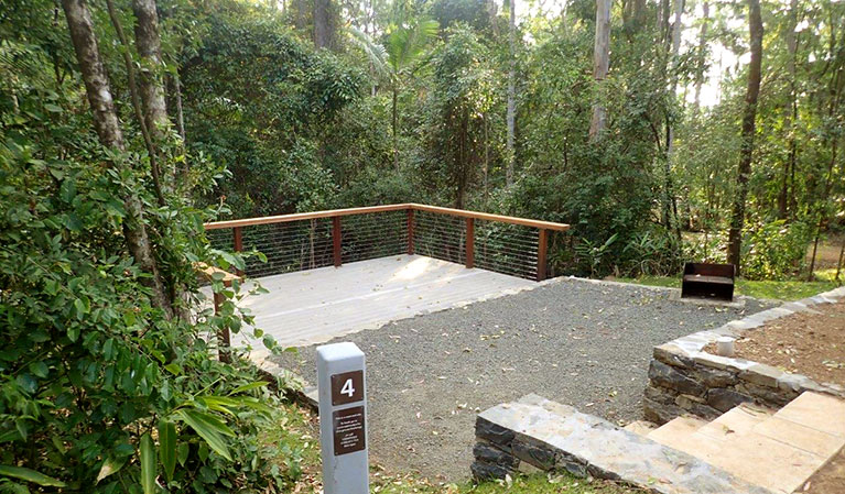 A camping deck in Sheepstation Creek campground set amongst bushland in Border Ranges National Park. Photo: Stephen King &copy; DPIE