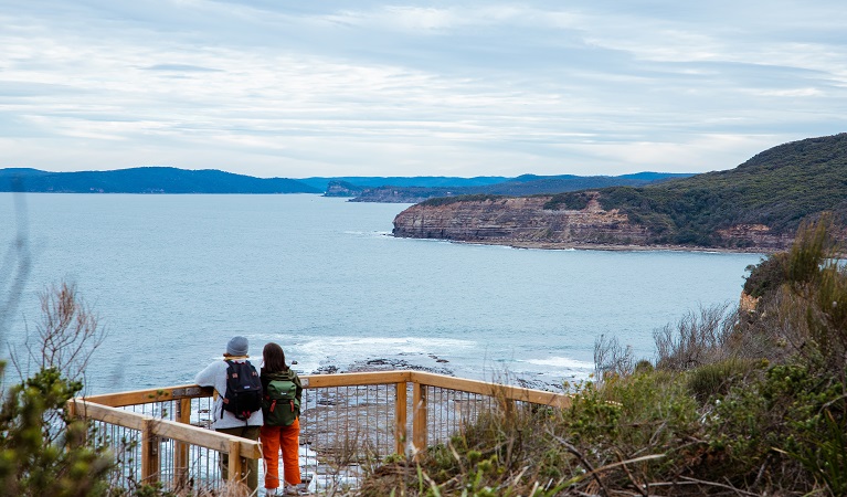 Couple enjoying views of the rugged coastline from Mullian lookout. Photo: Daniel Parsons © DPE