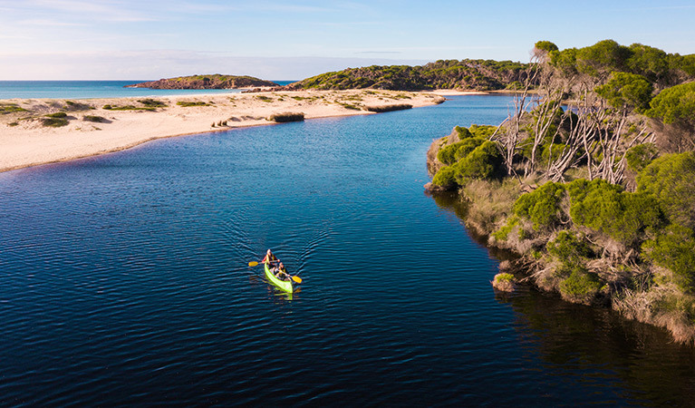 Two people in a canoe on Bournda Lagoon, Bournda National Park. Photo: Daniel Tran/DPIE