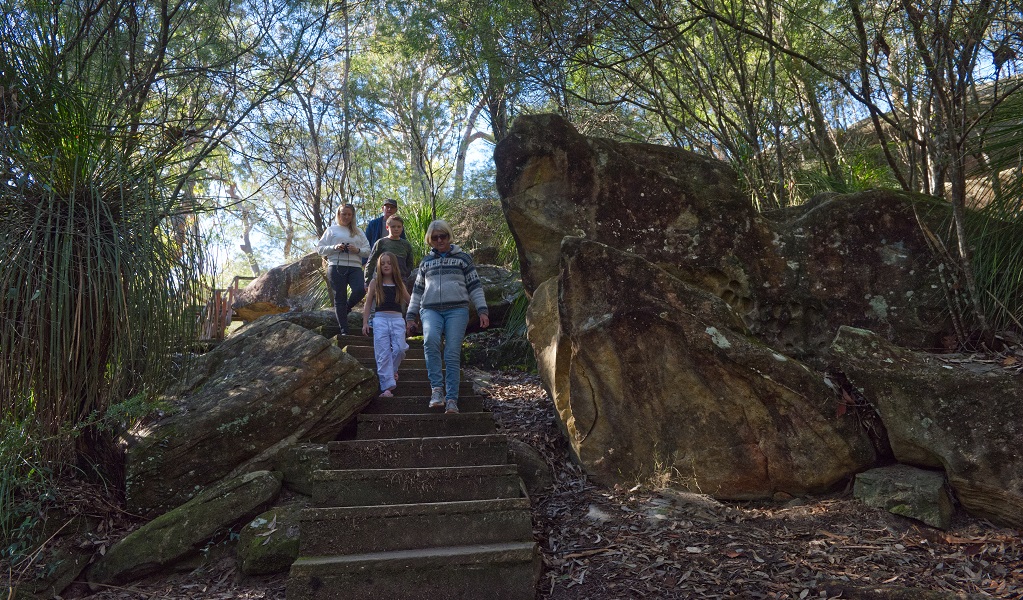A family group set off down the steps along Somersby Falls walking track, Brisbane Water National Park. Credit: Stuart Cohen, Bottle Brush Media © DCCEEW