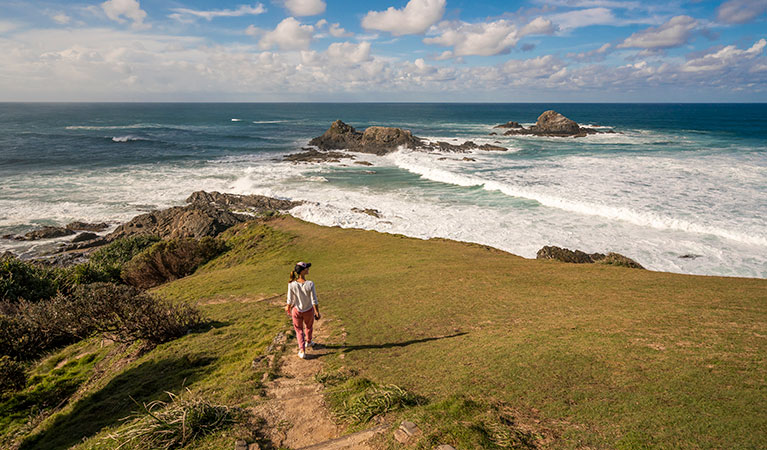 A woman walking down Three Sisters walking track towards the ocean in Broken Head Nature Reserve. Photo: John Spencer/DPIE