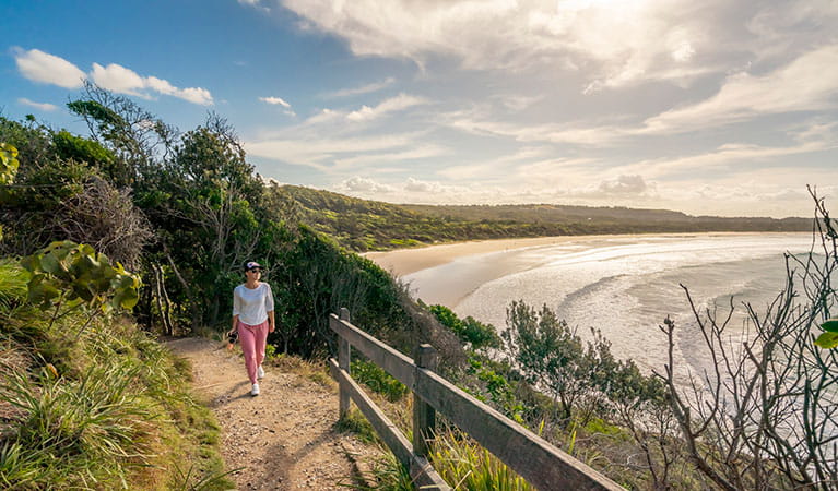 A woman walking along Three Sisters walking track, overlooking the beach in Broken Head Nature Reserve. Photo: John Spencer/DPIE