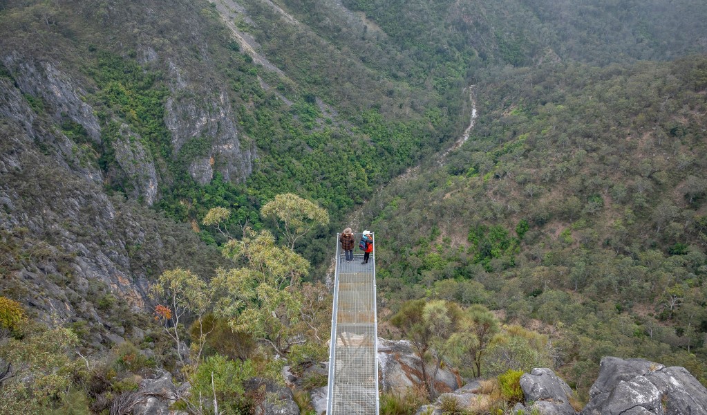 An aerial view of 2 people standing at the end of the lookout platform at The Lookdown lookout in Bungonia National Park. Photo: John Spencer &copy; DCCEEW