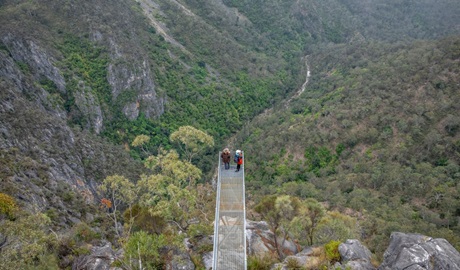 An aerial view of 2 people standing at the end of the lookout platform at The Lookdown lookout in Bungonia National Park. Photo: John Spencer &copy; DCCEEW
