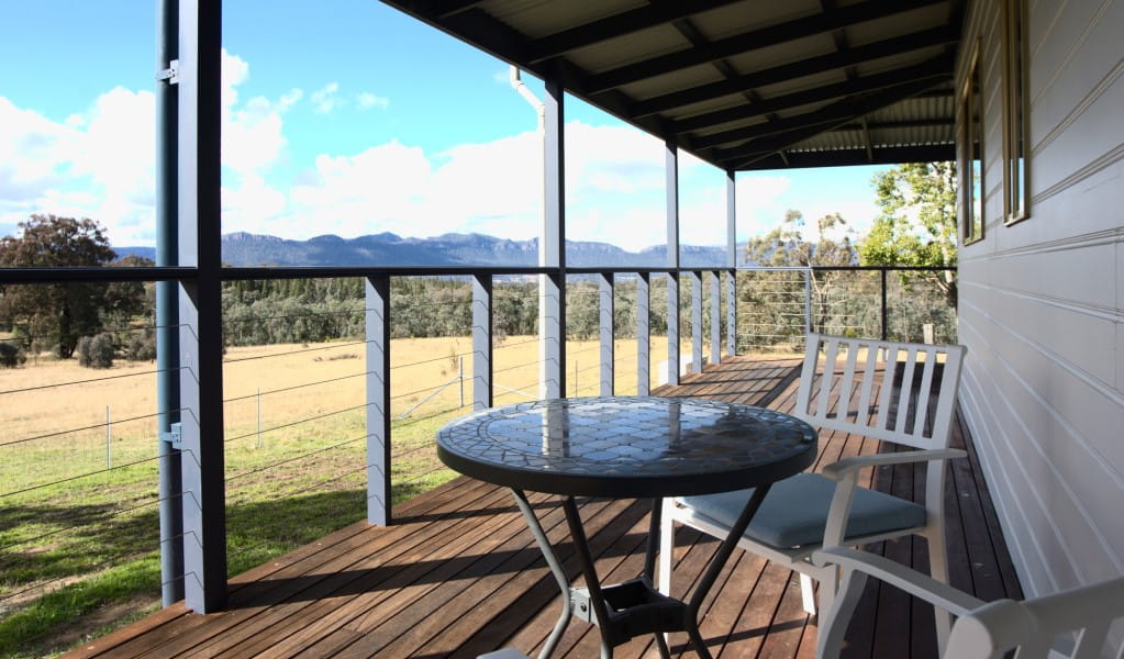 The wrap-around verandah with table and chairs at Honeyeater Homestead looking out to Capertee National Park. Photo: Steve Garland &copy; DPE