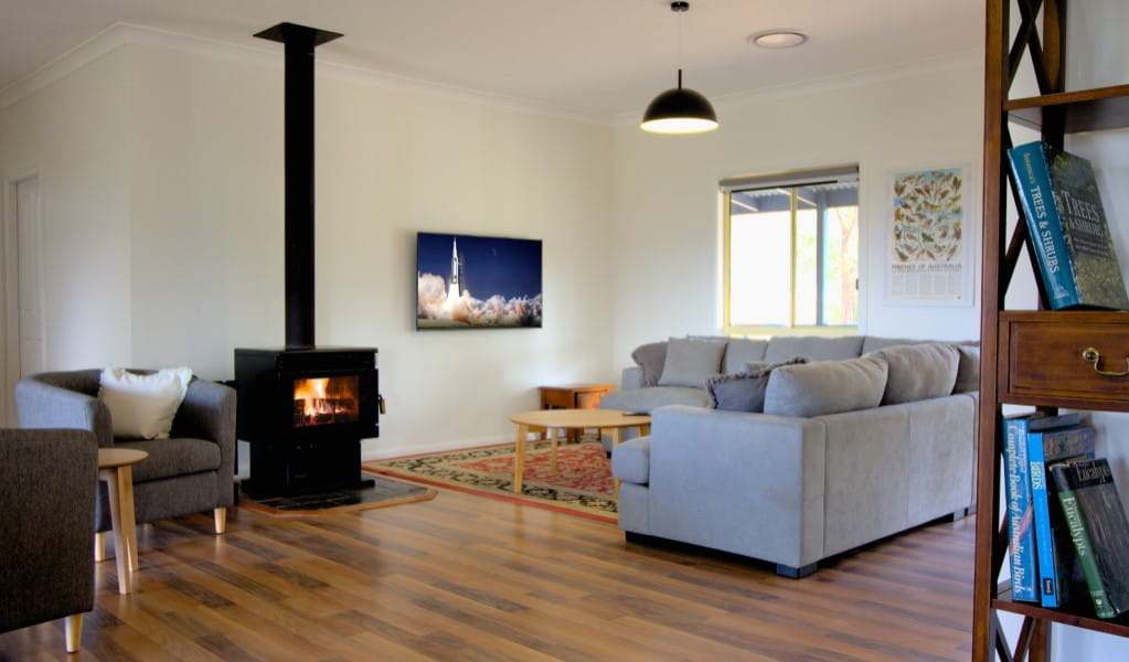 The open-plan living room with indoor fireplace at Honeyeater Homestead in Capertee National Park. Photo: Steve Garland &copy; DPE