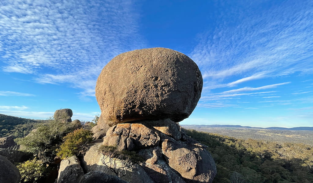 View of the large sphere of Cathedral Rock perched on a rock outcrop in a rugged and rocky bush landscape. Photo &copy; Tina Sullivan