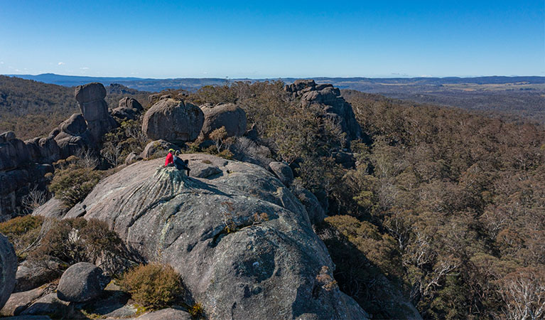 2 hikers sitting at the summit of Cathedral Rock, Cathedral Rock National Park. Photo: Josh Smith &copy; DPE