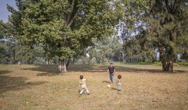 A man playing ball games with two children at Cattai campground in Cattai National Park, on the Hawkesbury River. Photo: John Spencer/OEH