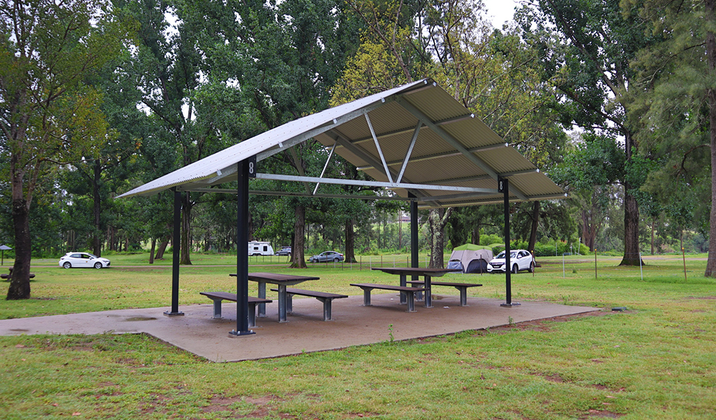 A picnic shed with two picnic tables underneath, at Cattai Farm picnic area in Cattai national Park, on the Hawkesbury River. Photo: David Bush &copy; DPE